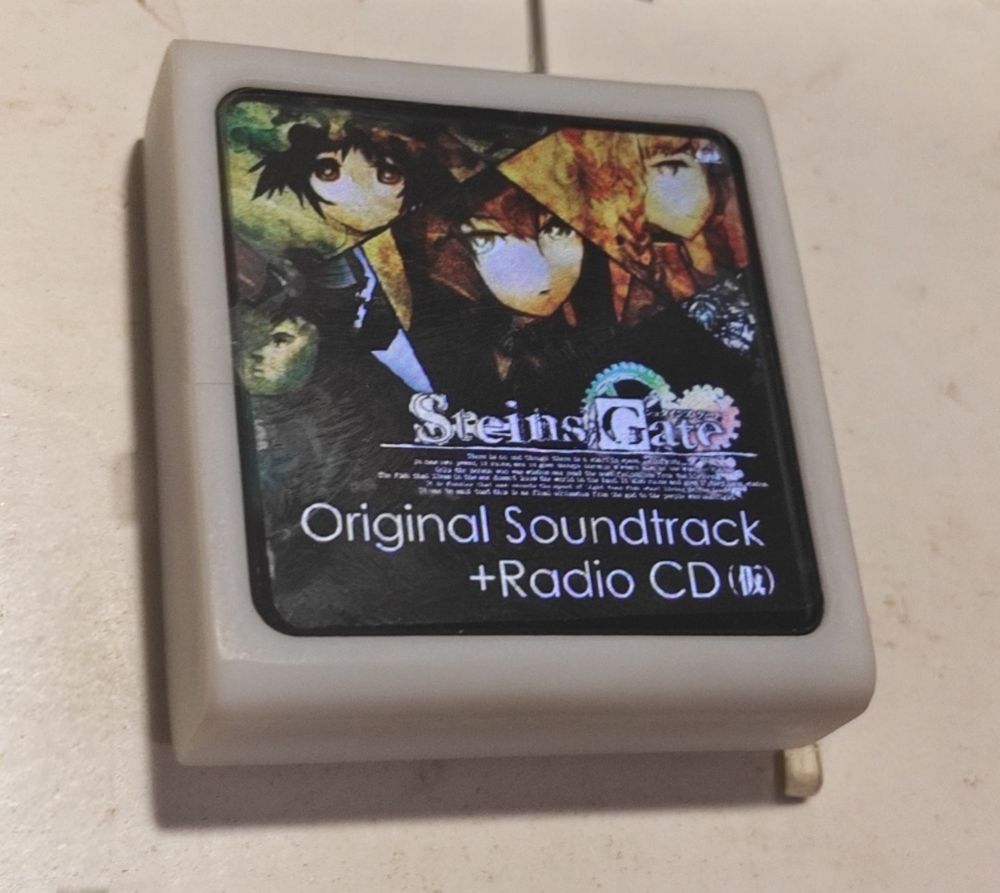播放器放在桌上，屏幕里显示一张专辑封面（Steins;Gate 原声带）